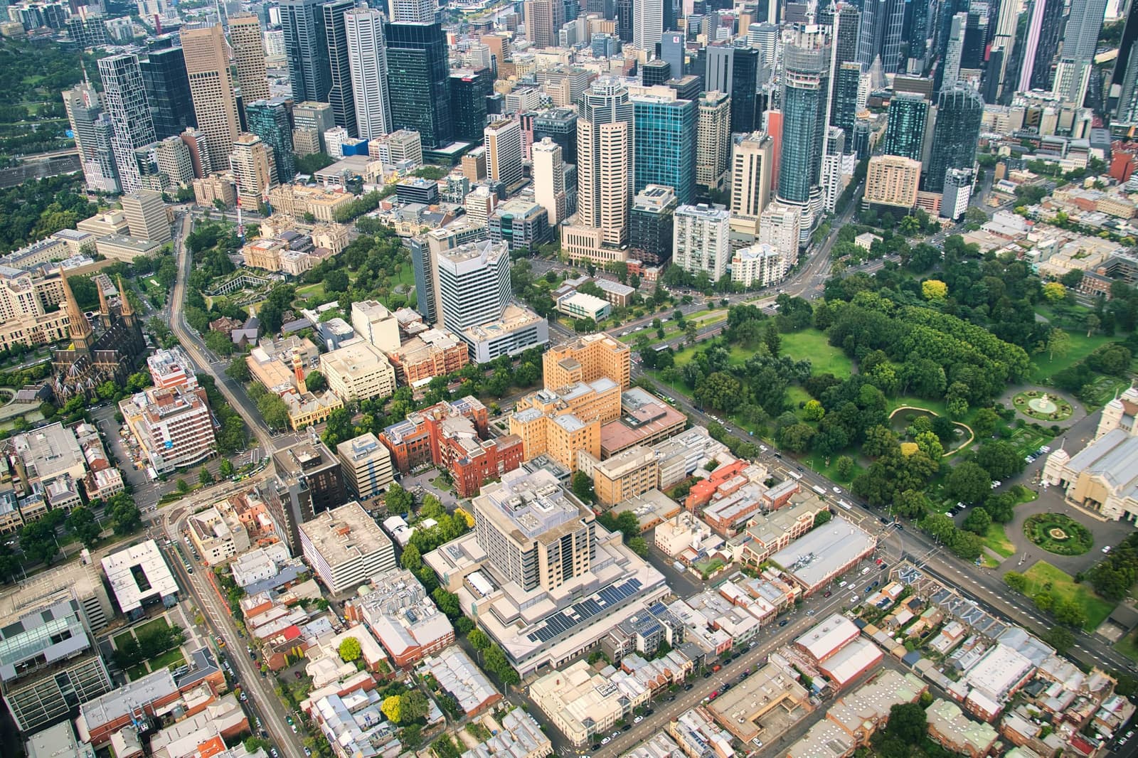 Aerial photograph of the east end of the Melbourne CBD, over Carlton Gardens, with the Harrow & Vale office building at the top of Collins Street outlined in orange.