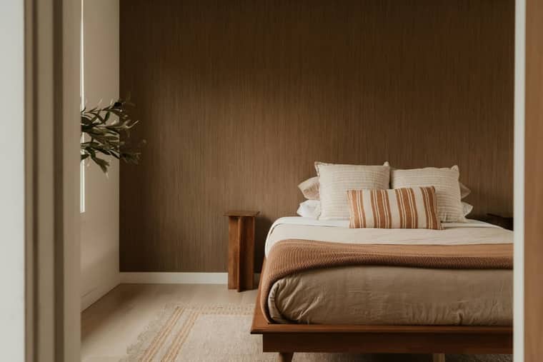 Residence 4: a bedroom with a grasscloth wall and a low timber bed.